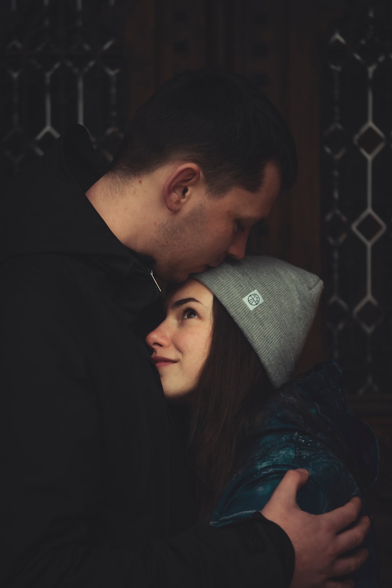 man kissing woman's forehead