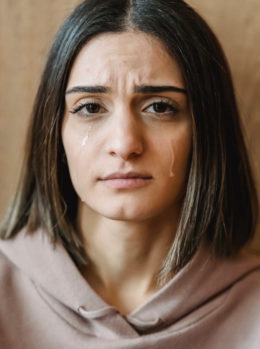 Sad female crying and looking at camera