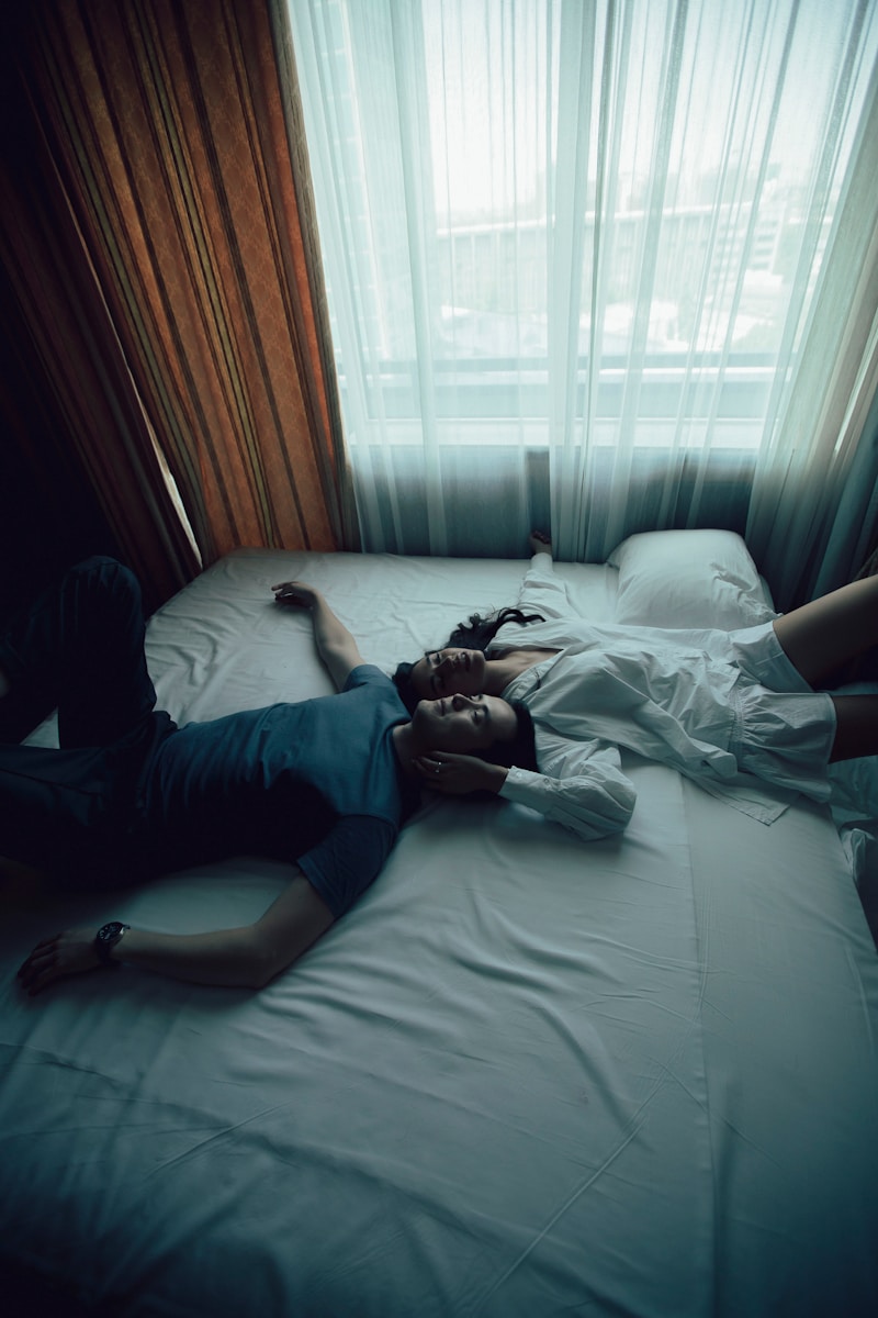 man in blue shirt lying on bed