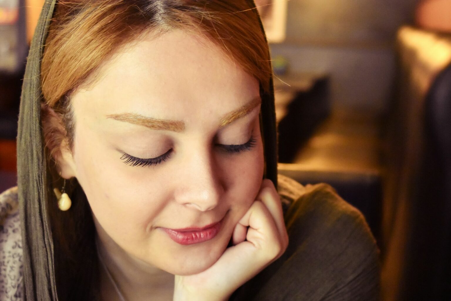 a woman sitting down with her eyes closed